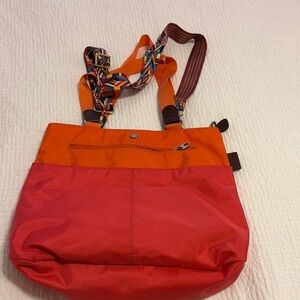 Mosey orange and pink tote with attached handles and crossbody removable strap.